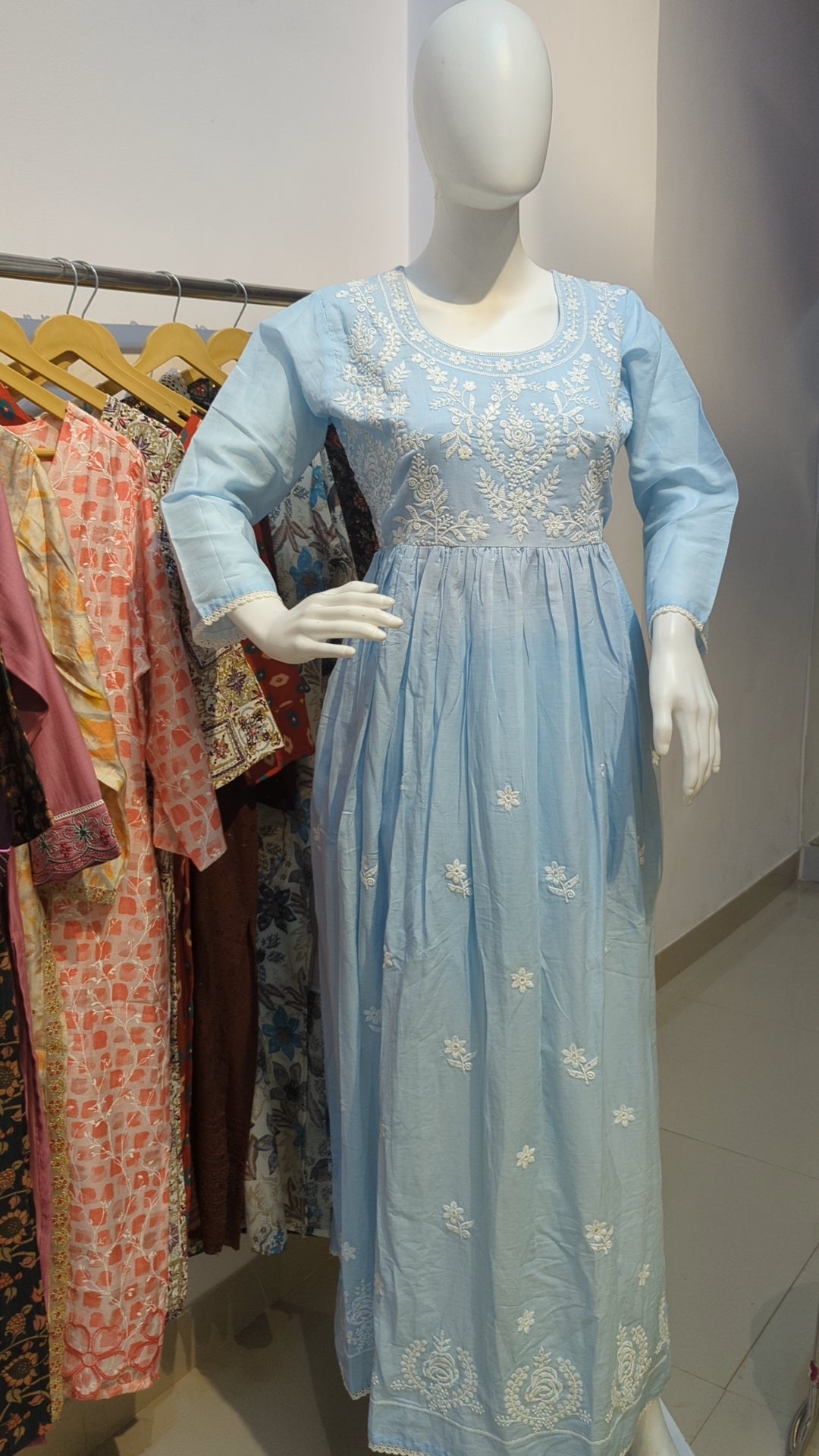 Close-up of white floral embroidery work on light blue kurta

