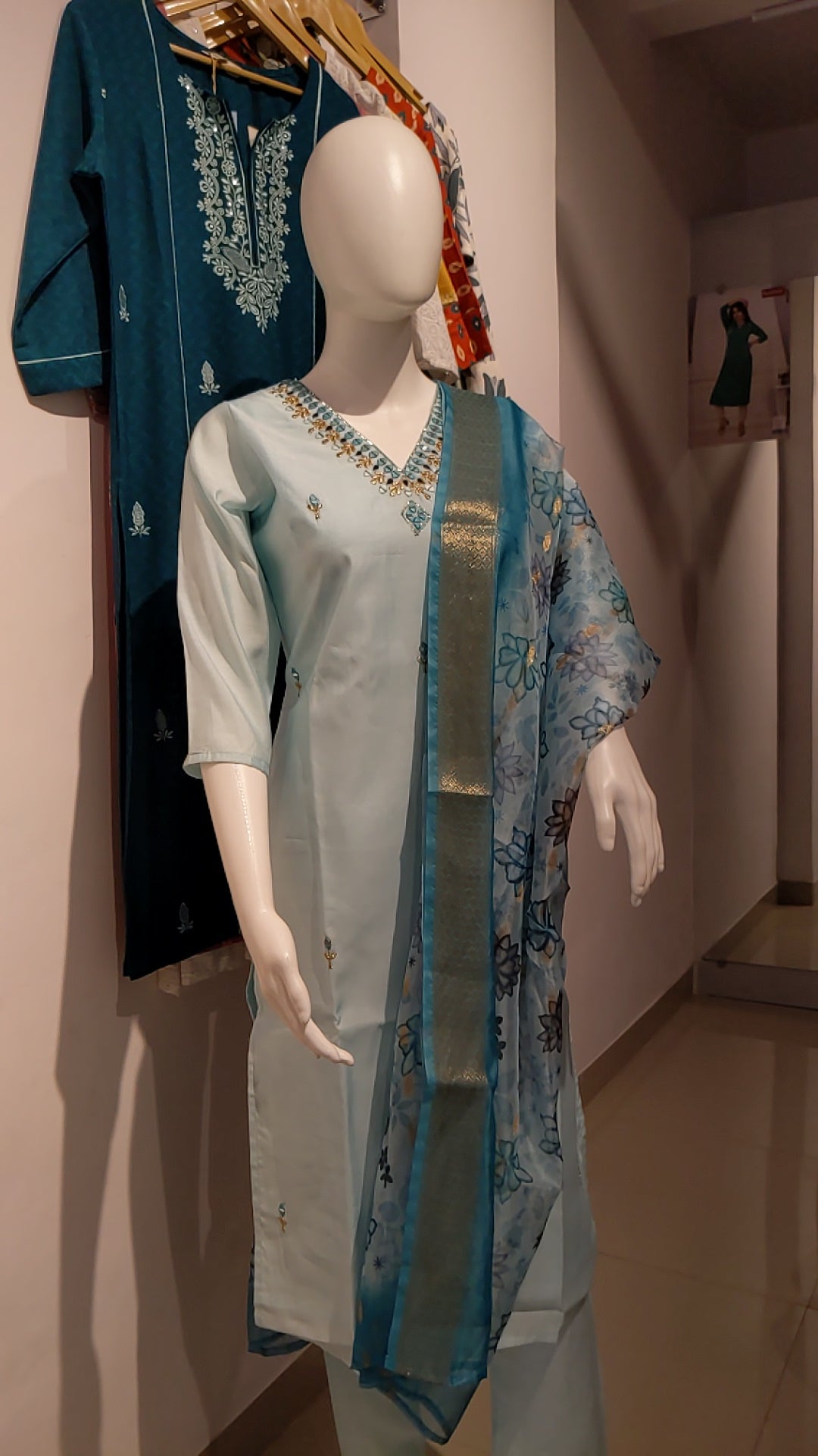"Sky blue Roman silk suit with organza dupatta displayed on mannequin"

"Flat lay of embroidered kurta, pants, and printed dupatta