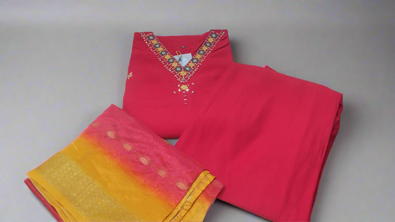 "Vibrant pink Roman silk suit with multicolour embroidery and ombre organza dupatta"

"Flat lay of pink silk suit set with yellow-pink organza dupatta"